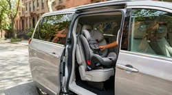 Empty child safety seat installed in the backseat of a car rental parked on a New York avenue