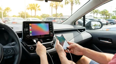 Driver plugging a smartphone cable into the dashboard to display Android Auto in an Orlando car rental