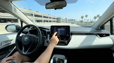 Person adjusting a digital dashboard display inside a car rental in Los Angeles