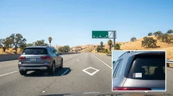 A silver car rental driving in a diamond marked carpool lane on a California highway