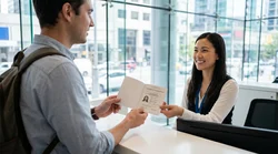 Person holding an International Driving Permit at a car rental desk in New York
