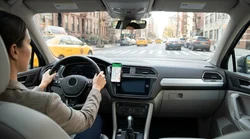Hands-free phone on a dashboard mount showing GPS navigation inside a New York car rental