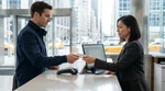 Customer handing a credit card to an agent at a car rental desk in New York