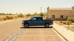 Silver car rental driving along a long straight desert highway in Texas