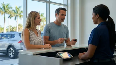 Close up of a hand holding a credit card at a car rental counter in sunny Florida