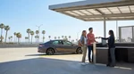 Silver car rental driving on a winding coastal highway in California overlooking the ocean