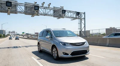 White car rental passing under a cashless toll gantry on a New York bridge