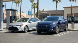 Modern electric car rental driving on a sunny palm-lined street in Los Angeles
