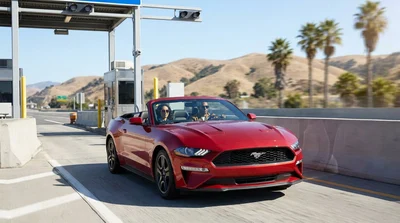 Silver car rental passing under an electronic toll gantry on a California highway