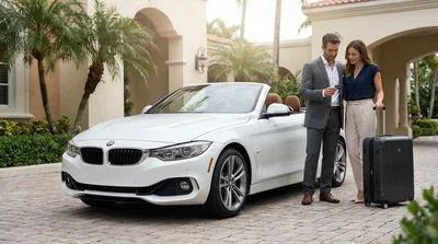 A sleek convertible car rental parked beside tropical palm trees on a sunny street in Miami
