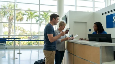 Person receiving keys from an agent at an outdoor car rental lot in Florida