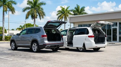 Family loading luggage into a white SUV car rental parked near palm trees in sunny Florida