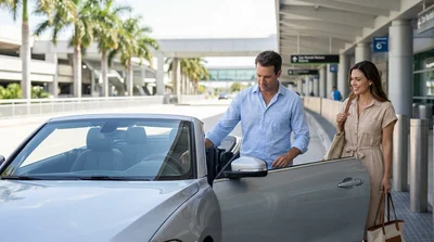 Interior view of a car rental steering wheel facing a sunny road lined with palm trees in Florida