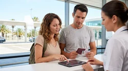 Customer handing travel documents to an agent at a car hire counter in Las Vegas