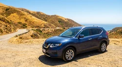 Black AWD SUV car rental driving on a rugged dirt road in California