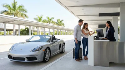 A traveler being handed keys for a car hire at an airport service counter in Miami