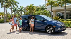Two passengers smiling inside a car rental driving along a sunny Florida beach road
