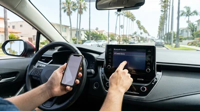 Hand deleting a paired phone from a car rental dashboard touchscreen in California