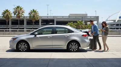 Traveler with luggage walking toward a parked vehicle at a Los Angeles car hire lot