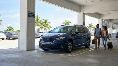 Traveler pulling a suitcase toward a parked vehicle in a Miami airport car rental lot
