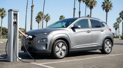 Charging cable plugged into an electric car rental parked near palm trees in California
