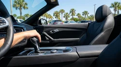Close up of a hand on a manual gear shift inside a car rental on a sunny highway in Florida