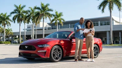 White convertible car rental driving down Ocean Drive past palm trees and beaches in Miami