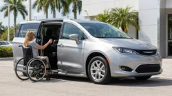 Steering wheel hand controls inside an accessible car hire parked on a sunny Florida street