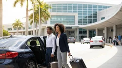 Passenger with luggage exiting a rideshare vehicle outside the car rental center in Orlando