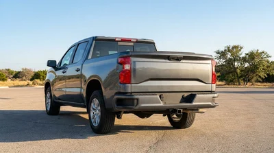 White car rental SUV equipped with a rear tow hitch driving along a sunny desert highway in Texas