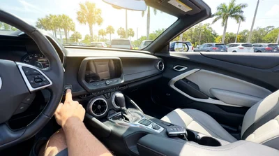 Close up of a hand pressing a keyless start button inside a car rental in Florida