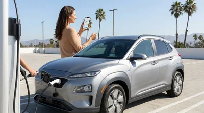Person plugging a charging cable into an electric car rental at a sunny public station in California