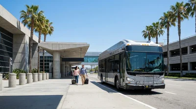 Travelers with luggage walking outside Terminal 1 in Las Vegas toward a car rental shuttle bus