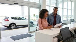 Traveler reviewing paperwork at an airport car rental counter in the United States