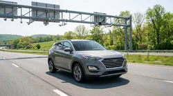 White car rental driving through an E-ZPass toll booth on a Pennsylvania highway