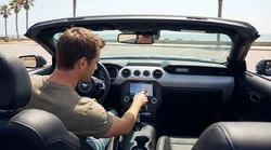 Close-up of a hand pressing an infotainment touchscreen inside a California car rental
