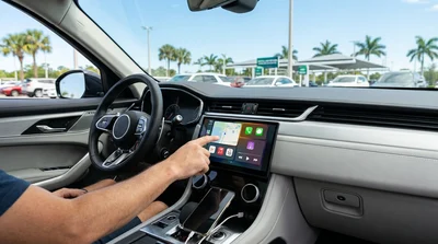 Close-up of a driver connecting a smartphone to the dashboard screen of a car rental in Florida