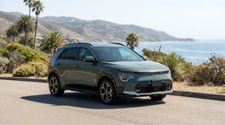 White crossover SUV car hire driving on a scenic coastal highway in California
