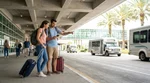 People with luggage waiting at the passenger pick-up point for a car hire shuttle bus at Orlando Airport