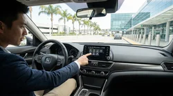 Driver checking the dashboard display inside a car rental parked on a sunny California street