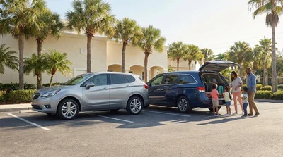 Family putting luggage into a white SUV car rental parked near sunny palm trees in Florida
