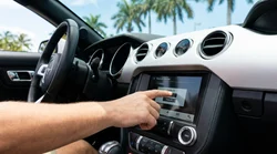 Driver tapping the infotainment touchscreen inside a Florida car rental