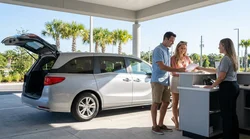 Customer handing a credit card to an agent at a car hire desk in Orlando