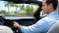 Digital speedometer dashboard display inside a Florida car rental with palm trees visible through the front windshield