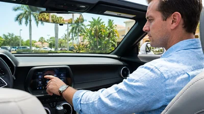 Digital speedometer dashboard display inside a Florida car rental with palm trees visible through the front windshield