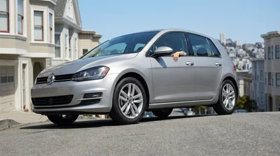 Silver car rental driving down a steep San Francisco street lined with classic houses