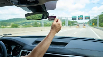 E-ZPass transponder attached to the windshield of a car rental driving on a Pennsylvania highway