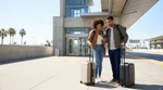 Traveler with a suitcase waiting at a car rental shuttle stop outside Union Station in Los Angeles