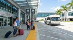 Car rental shuttle bus parked at the arrivals curb outside Terminal 3 in Los Angeles