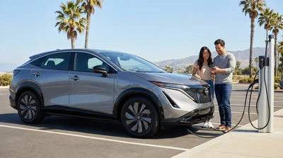 An electric car rental plugged into a charging station under palm trees in sunny California
